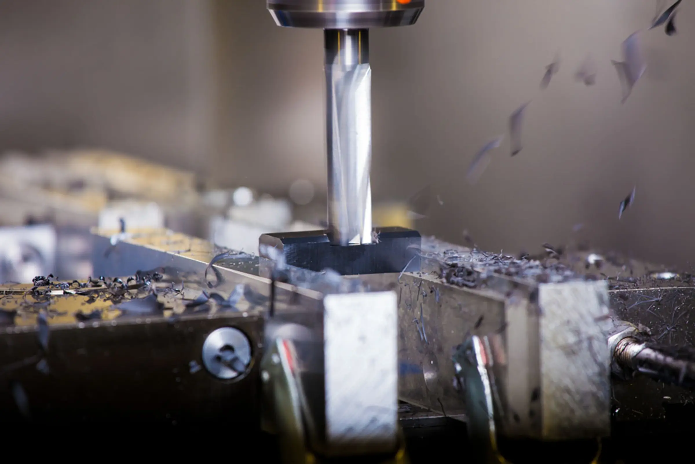 CNC-Fräser bearbeitet ein eingespanntes Werkstück, Späne fliegen